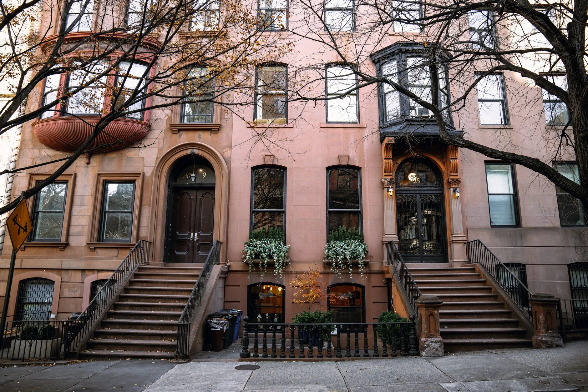 A row of Brooklyn brownstones with stoops and bay windows in autumn