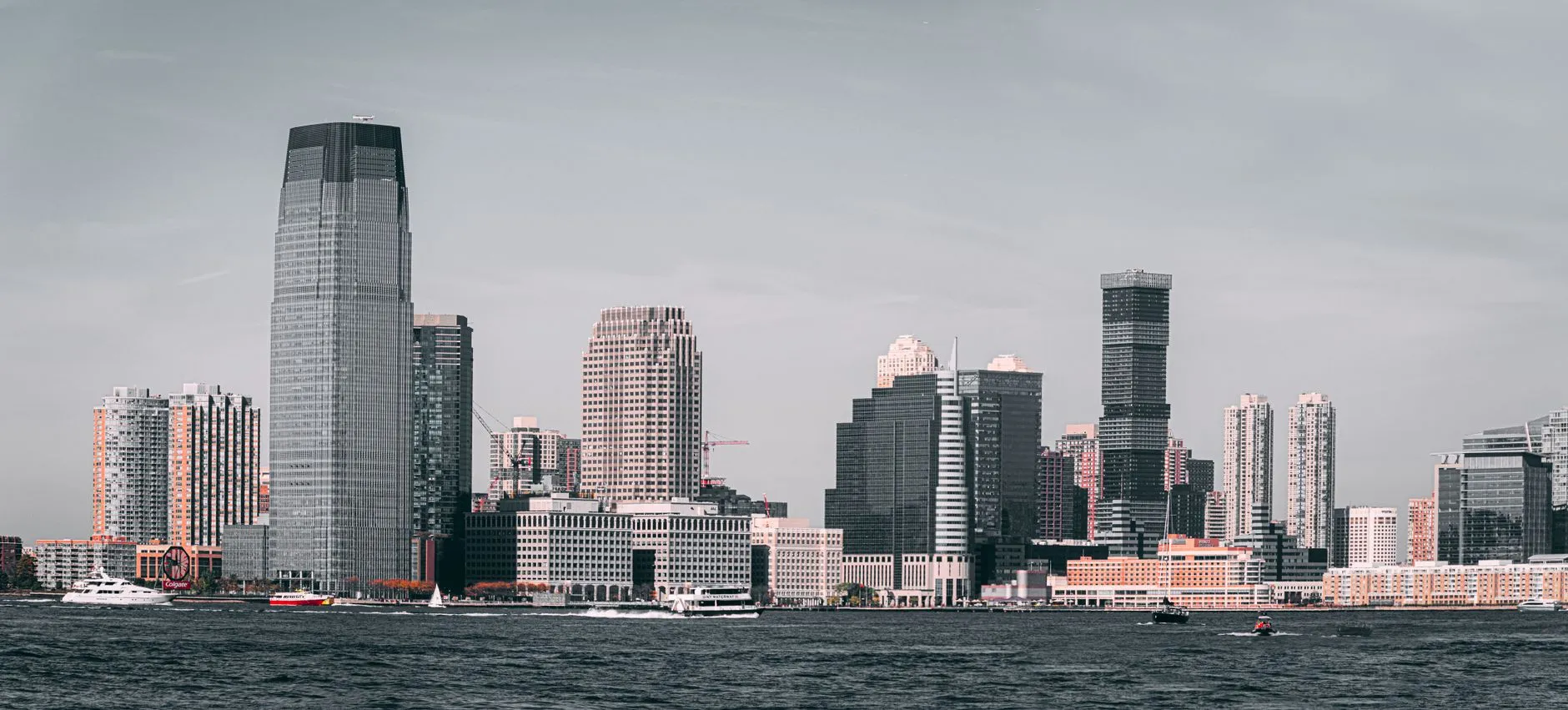 The Jersey City skyline seen across the Hudson River, with the Goldman Sachs Tower rising above the Colgate Clock on the waterfront.