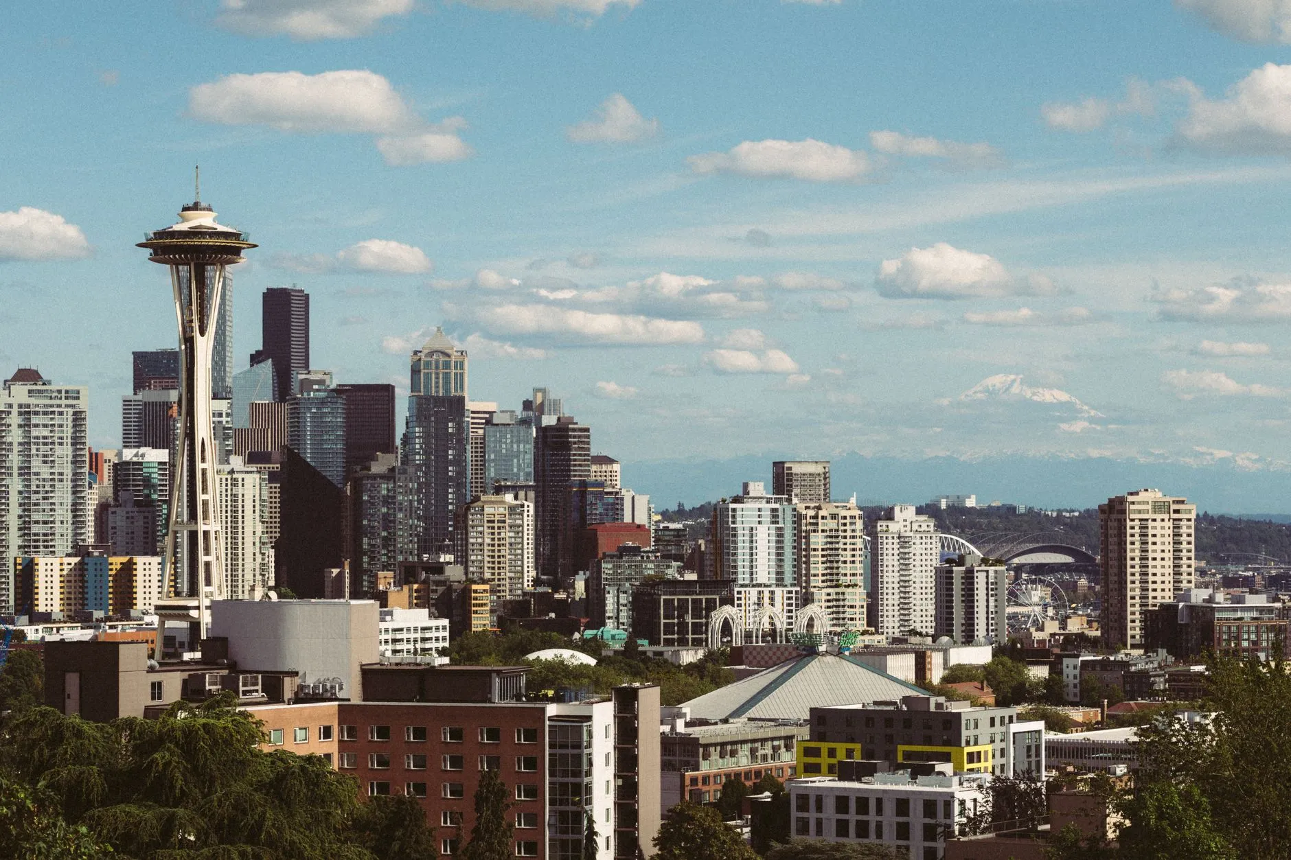 The Space Needle above the Seattle skyline, with Mount Rainier showing faintly on the horizon to the right